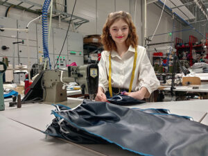 Katariina Juoperi ompelemassa teollisuuskoneella TITRYn ompelimossa.